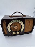 Front view of vintage Zenith radio showing the brown plastic case, speaker grille, tuning dial, and control knobs.