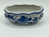 Photo showing the front side of vintage ceramic bowl with blue floral design and crackle glaze.