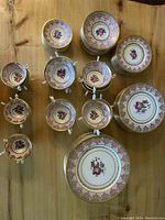 Overhead view of assorted plates and handled soup bowls on wooden surface