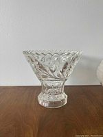 Photo shows a clear glass bowl approximately 6 inches tall with an embossed leaf design and scalloped rim.