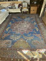Overview of the rug laid out on living room floor showing central medallion, field design, and border.