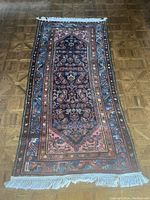 Full view of the hand-knotted Kerman area rug showing central medallion, border and knotted fringes