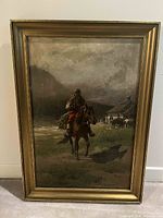 Front view of framed oil painting depicting a man on horseback in rural landscape