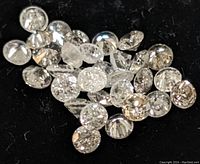 Close-up view of loose round brilliant diamonds on black background