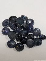 Close-up of round faceted natural sapphire gemstones showing color and cut variations.