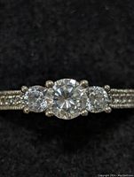 Close-up front view of sterling silver ring with three round cubic zirconia stones on a beaded decorated band.