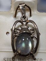 Front view of the sterling silver labradorite pendant showing the oval labradorite stone and open frame with insect-like design.