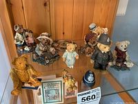 Miniature teddy bears arranged on a shelf, includes boyds bears, cherished bear, and bertram bear figurines, seated and standing, with small plaques and ceramics