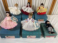 Six dolls from the Alexander Doll Company displayed on their original blue boxes showing the overall lot contents and condition.