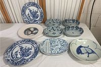 Overall display of the dish collection including two hanging plates, four small rectangular bowls, and two additional plates.