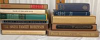 Stacked spines view of classic hardcover books including Tales of the Gold Rush, Swiss Family Robinson, Saint Thomas Aquinas, Poor Richard's Almanack, and others.