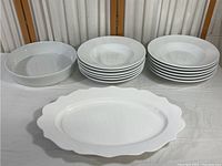Photo showing all dinnerware items together, including large oval platter, bowls, and stacked plates.