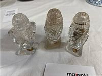 Photo showing three cut glass salt and pepper shakers with faceted cut patterns and square bases.