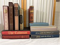 Front view of 11 vintage hardcover books with various titles and colors on their spines, showing some aging and fading.
