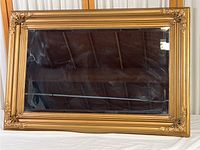 Full view of the large rectangular mirror with ornate gold frame showing its overall size and condition.