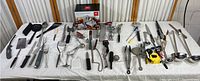 Wide view of the entire kitchen utensil collection laid out on white tablecloth
