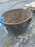 Photo showing exterior and interior rust on the vintage wrought iron pot with handle.