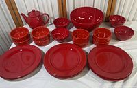 Overview of entire red ceramic Waechtersbach dish collection including teapot, plates, bowls, and crocks.