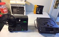 View of both projectors with Keystone Zoom Movie Projector on left and Kodak Carousel slide projector on right, showing overall condition and setup.
