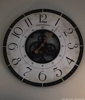 Full view of the large round wall clock with visible gears and two rings of numbers