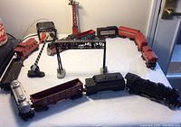 Full layout of two vintage model train sets on white surface including locomotives, train cars and accessories