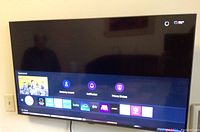 Front view of Samsung 42 inch flatscreen TV powered on and displaying the smart TV menu with apps and notifications visible.