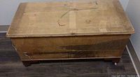 Front and top view of the vintage wooden hope chest showing aged wood surface and pencil sketches.