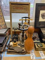 Photo showing antique test tube spinner marked Fisher Scientific Co., bowling pin, mini sled, ice skates, and water flask grouped together