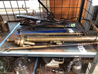 Wide view of table with brass pipes, valves, and other brass tool parts.