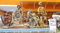 Group photo showing all seven cast bronze sculptures with various figures including Abraham Lincoln, miner, fisherman, and dancing lady.