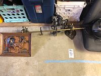 Full view of metal coat rack with horse statue and carriage wall art on floor next to storage crates.