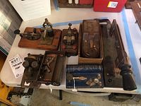 Photo showing a table with multiple vintage telegraph keys and Codemaster device, various sizes and shapes on wooden bases and boxes.