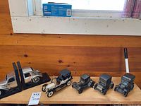 Overview of 2 Rolls Royce metal bookends and 4 small collectible vintage cars, showing their relative sizes and condition.