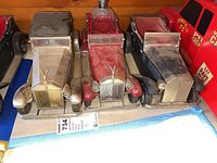 Front view of three Rolls Royce model car decanters showing detailed grille, mascot, and varied colors.