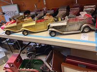 Three Rolls Royce car-shaped decanters displayed on a table with visible detailing highlighting metal and glass elements.