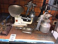 Wide shot showing three spray painters and Triner scale on rusty surface