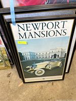 Close-up front view of Newport Mansions poster with vintage white convertible car in frame.