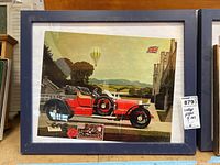 Full view of vintage framed poster showing red classic car, hot air balloon, British flag, and countryside scene.