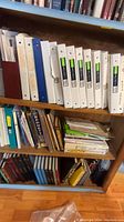 Photo showing top shelf with mostly white binders labeled with car-related content