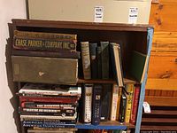 Whole view of two shelves packed with books about inventions and electricity including some vintage and reference titles.
