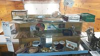 Top shelf with model cars, propeller hood ornament and Thom McAn box item
