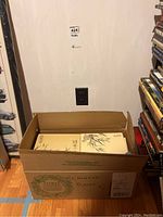 Closed large brown box labeled "Chinese Plates" containing twelve smaller box sets.