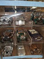 Front view of wooden display case holding nine diecast Rolls-Royce models on three shelves