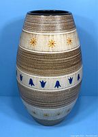 Front view of a large vintage West German pottery vase with textured brown bands and yellow floral decorations