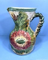 Front view of the mid century pottery jug showing large flower design and twisted handle