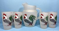Photo showing full pitcher and several glasses with rooster design against blue background