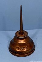 Copper oil can with visible wear and engraved Eagle branding on side taken from front view