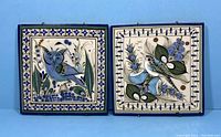 Pair of square pottery wall plaques with blue and green designs on a white background, showing the owl and floral motifs with floral borders.