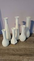 Front view showing all six milk glass vases assorted in two rows against a plain background.