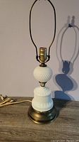 Full view of the vintage hobnail milkglass table lamp showing the entire body, brass base, and electrical cord